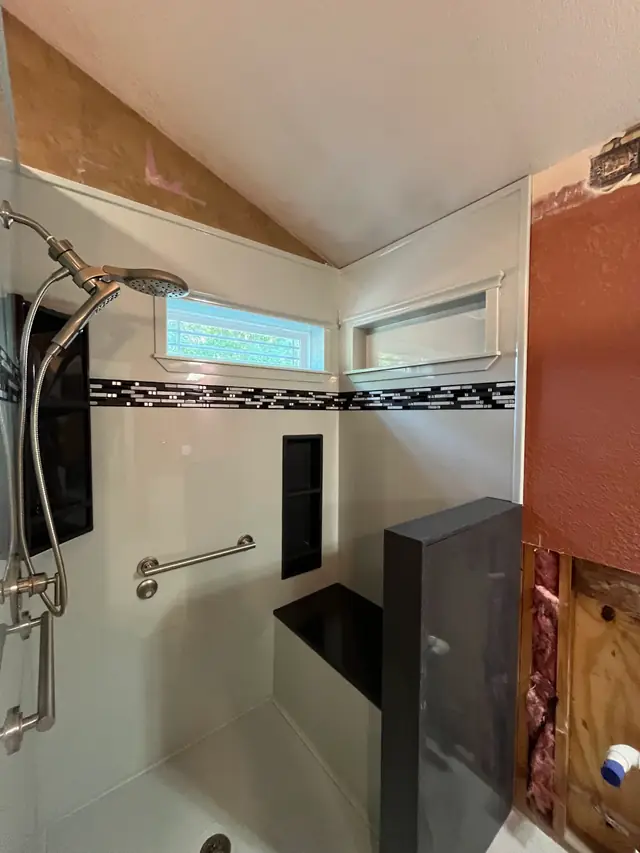 A shower wall opened down to the studs and insulation during an install