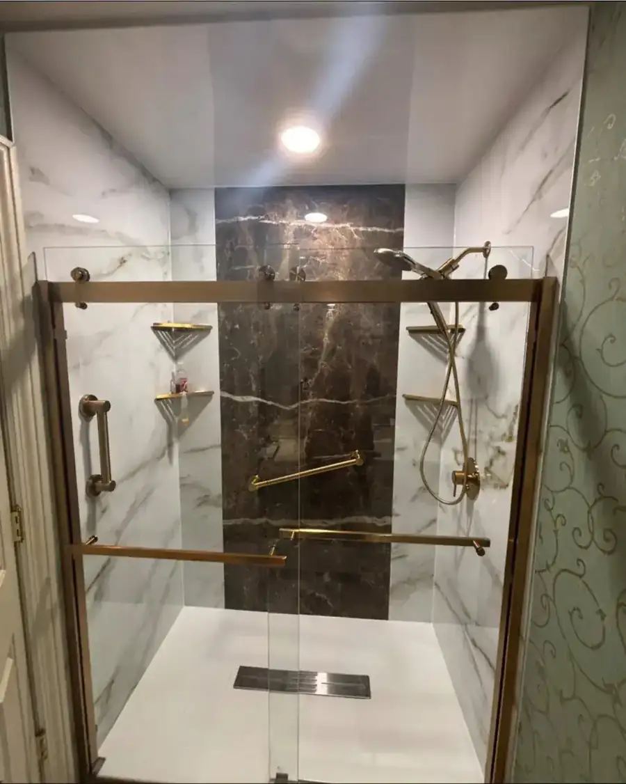 Bella Vista walk-in shower with white marble-look panels, a dark marble feature strip and a brushed gold slider