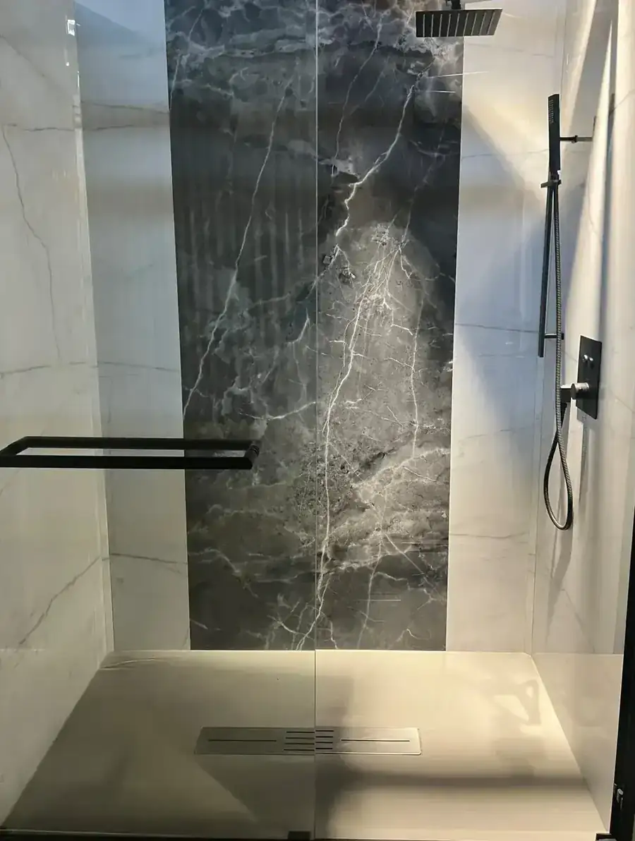 Elm Springs tub-to-shower conversion with a dark veined feature wall and a matte black shower wand