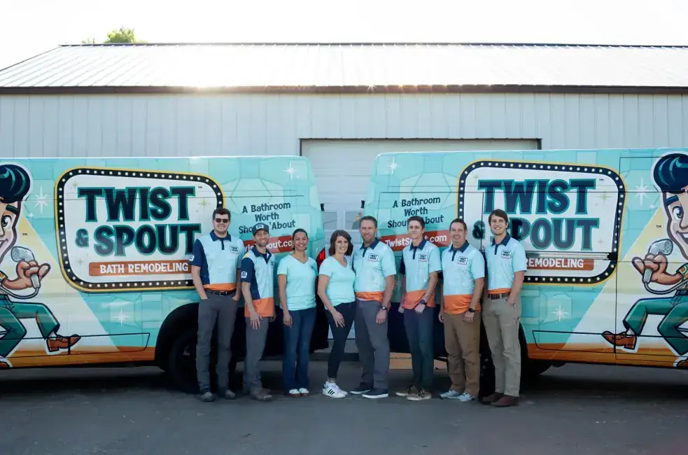 The Twist & Spout crew in company shirts standing in front of two wrapped company vans
